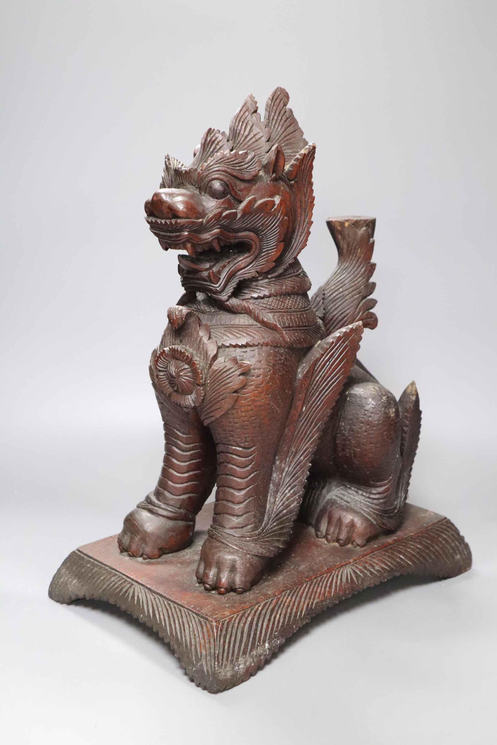 An Indonesian large carved wood model of a seated kylin, on plinth base and two Chinese rootwood carvings of elders, H approx 44cm (kyl